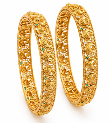 Pair of gold bangles with intricate designs on a white background