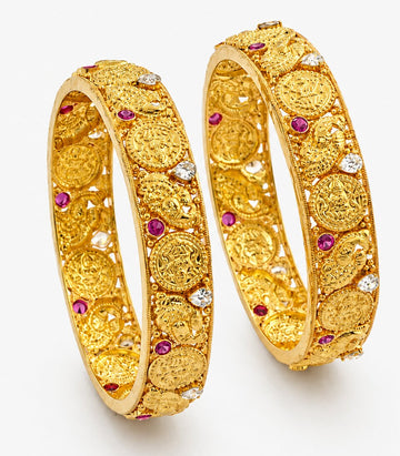 Pair Of Gold Bangles With Intricate Designs And Purple Stones