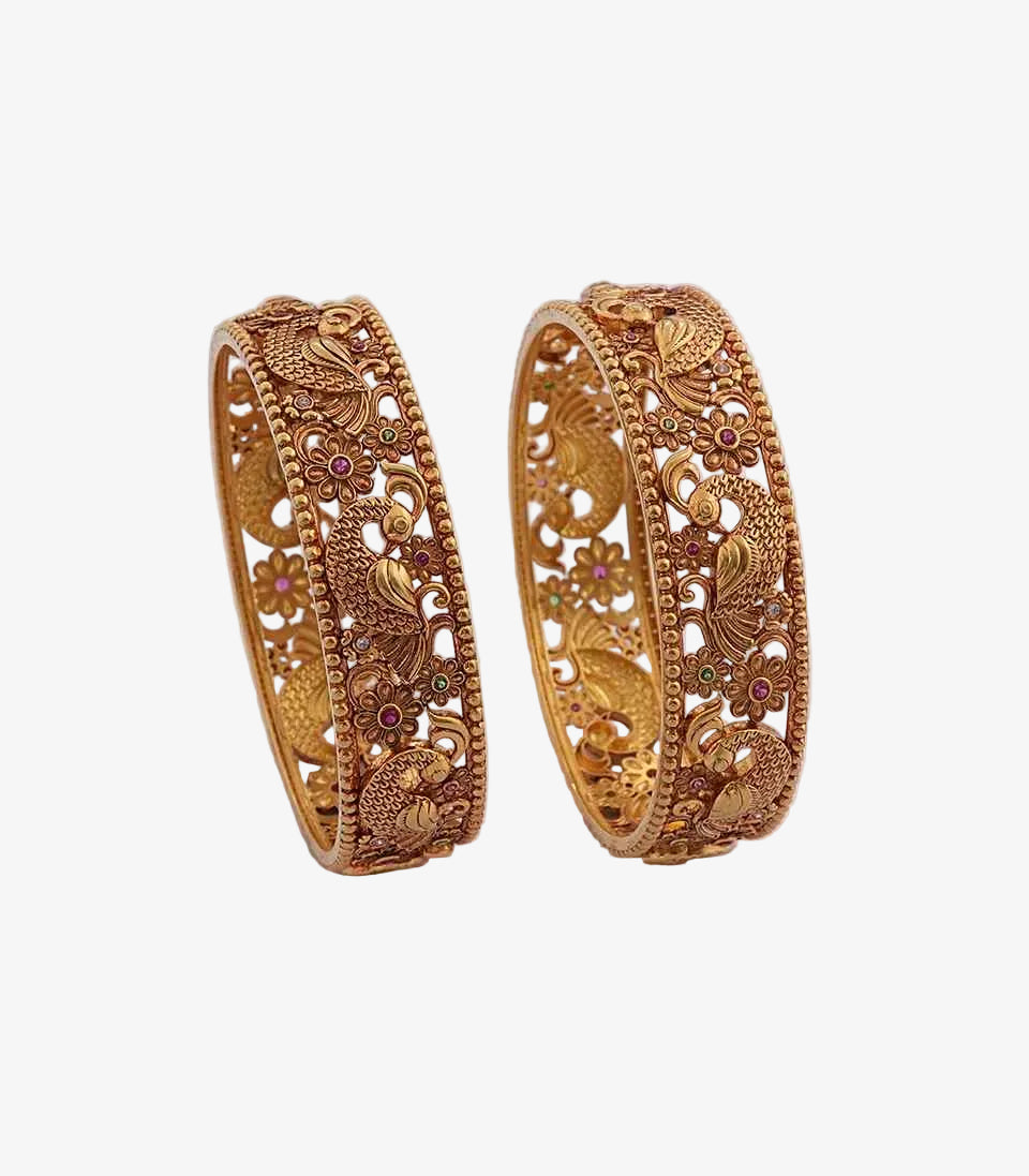 Pair of gold ornate bangles on a light background