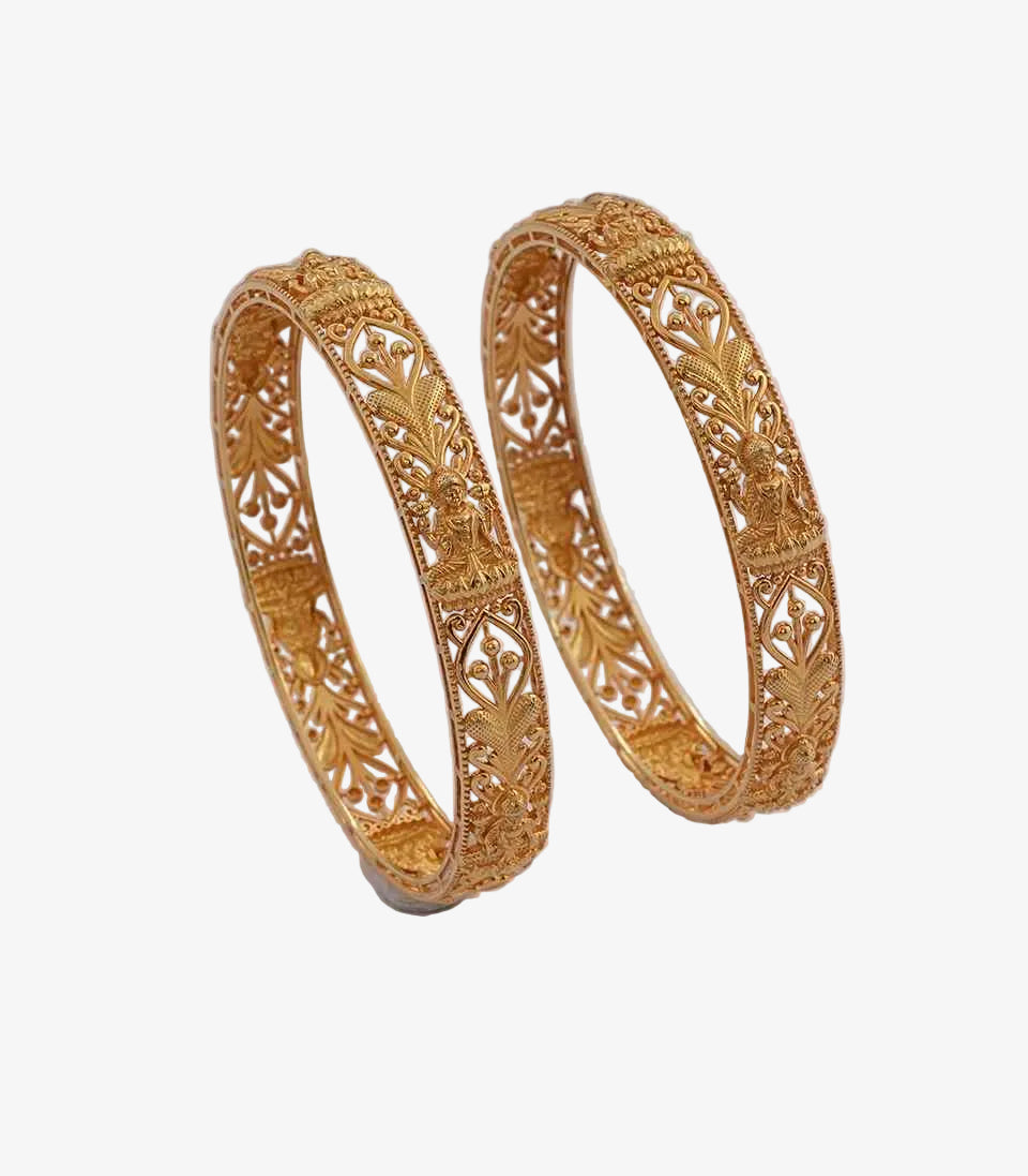Pair of gold bangles with intricate designs on a light gray background