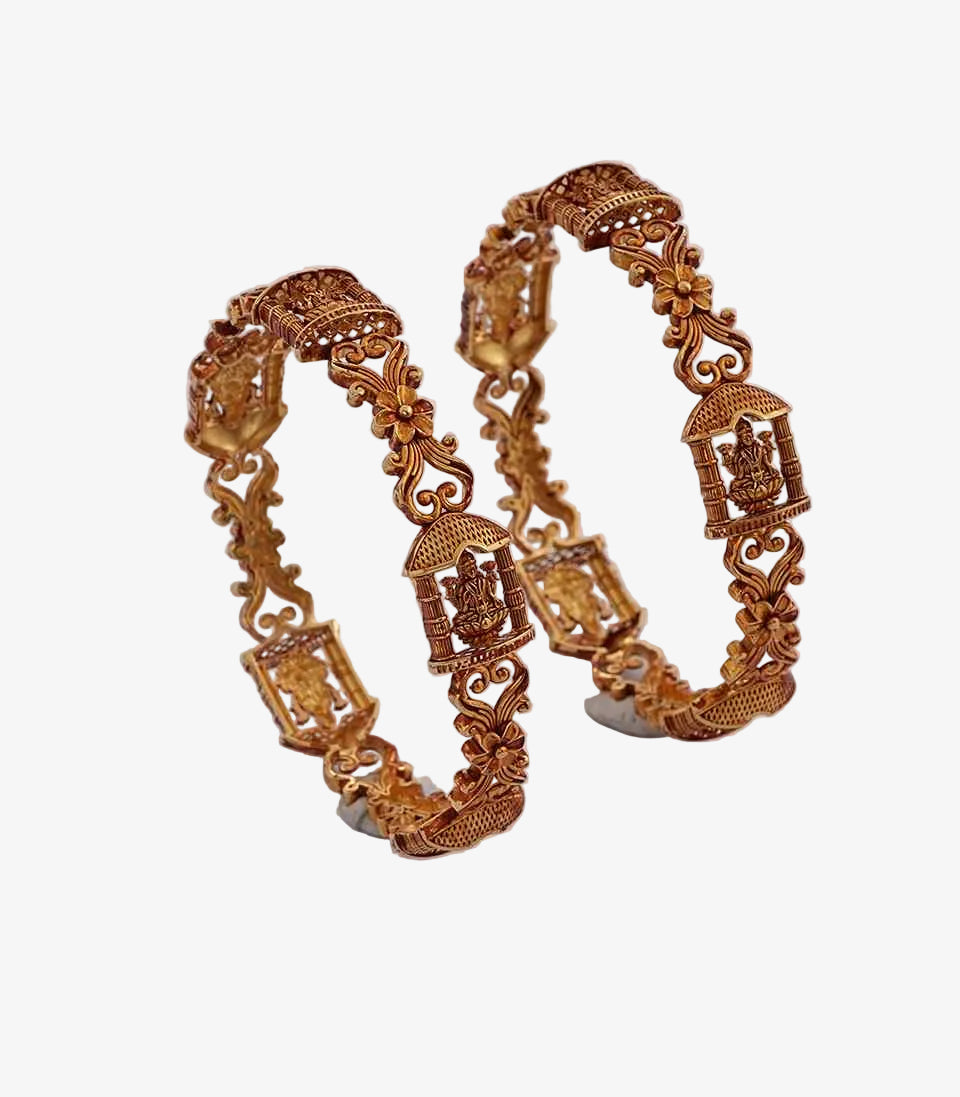 Pair of ornate gold bangles on a light  background
