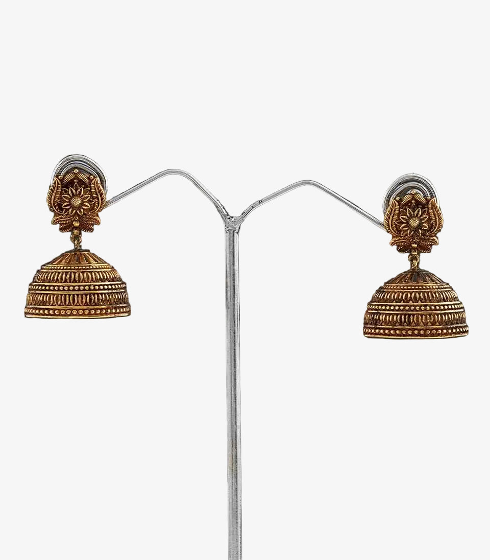 Pair of gold jhumka earrings  With Flower Design on a dark background
