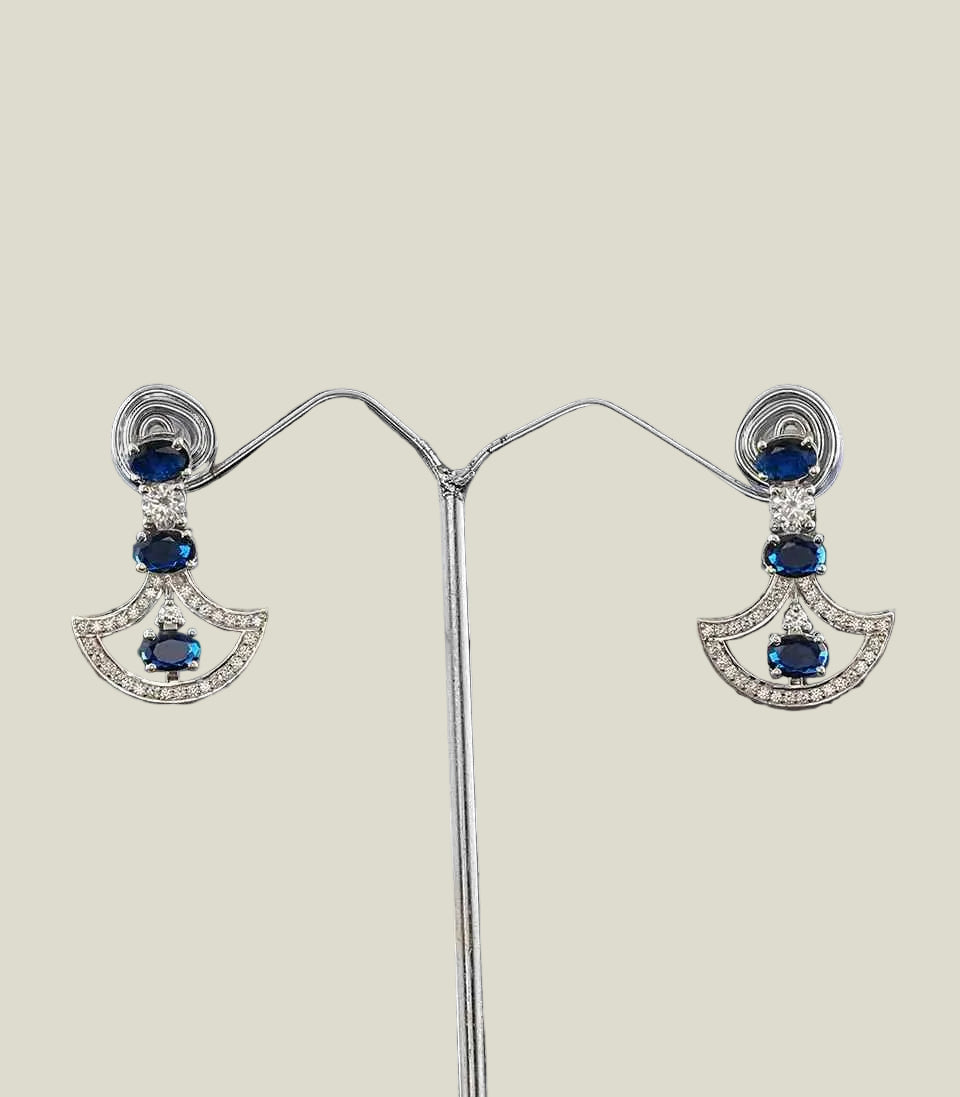 Pair Of Diamond Earrings With Blue Gemstones on a dark background