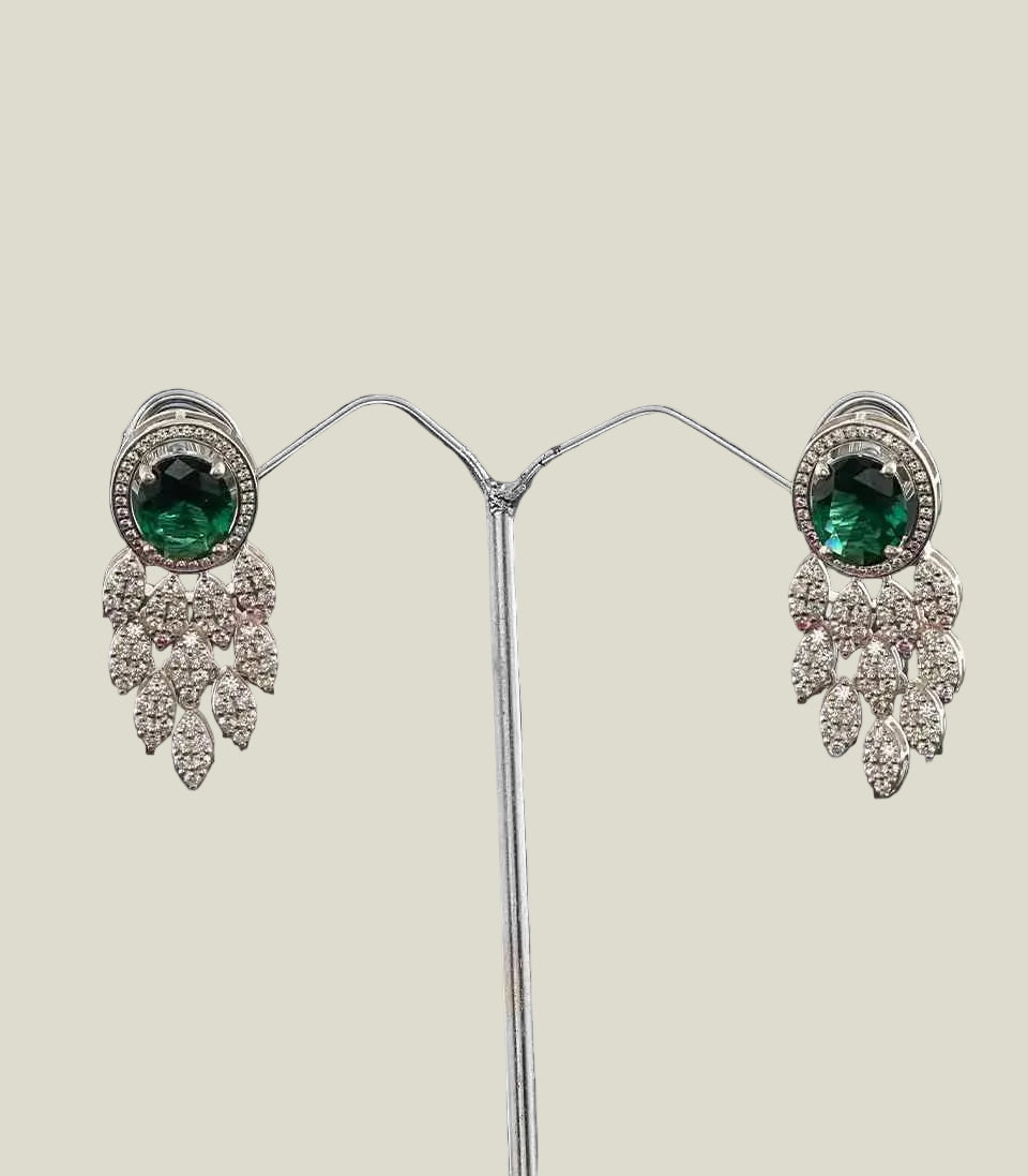 Pair Of Earrings With Green Gemstones And Diamond-Like Stones on a dark background