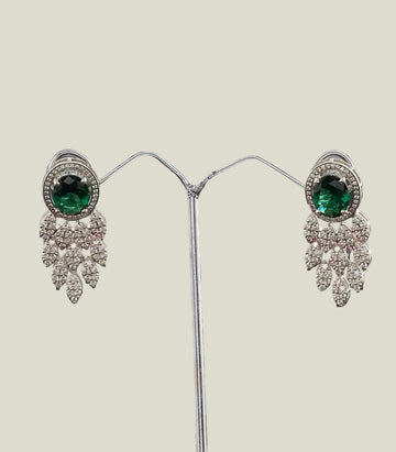 Pair Of Earrings With Green Gemstones And Diamond-Like Stones on a dark background