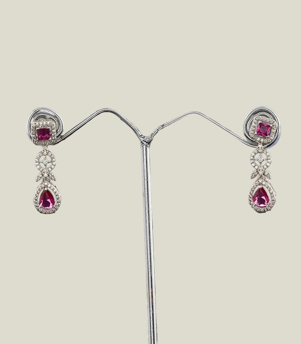 Pair of earrings with pink gemstones on a dark background