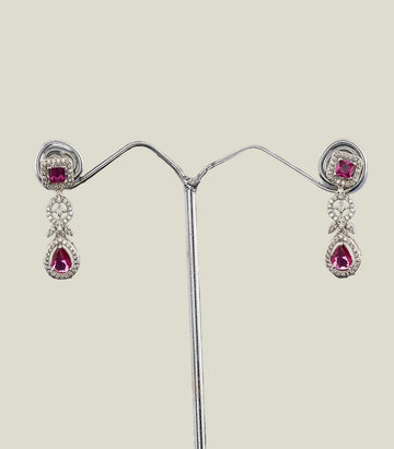 Pair of earrings with pink gemstones on a dark background
