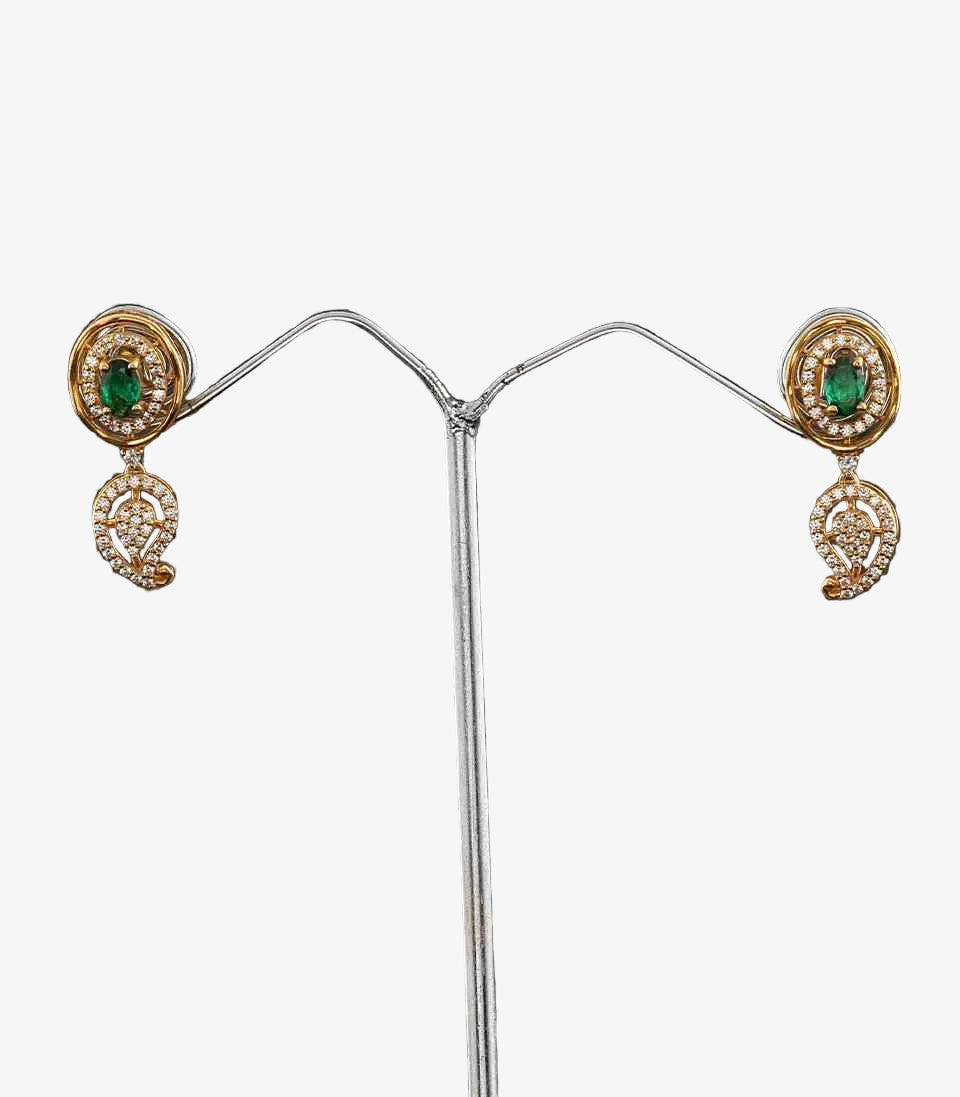 Pair Of Gold Earrings With Green Gemstones With Mango Design on a dark background