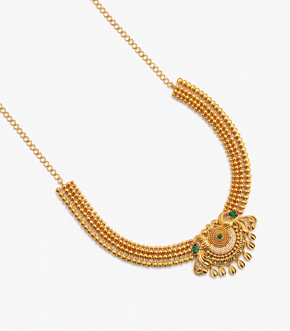A Long Gold Temple Haram Featuring A Large, Ornate Pendant