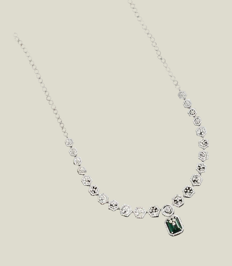 Silver necklace with a hexagonal pendant on a dark gray background