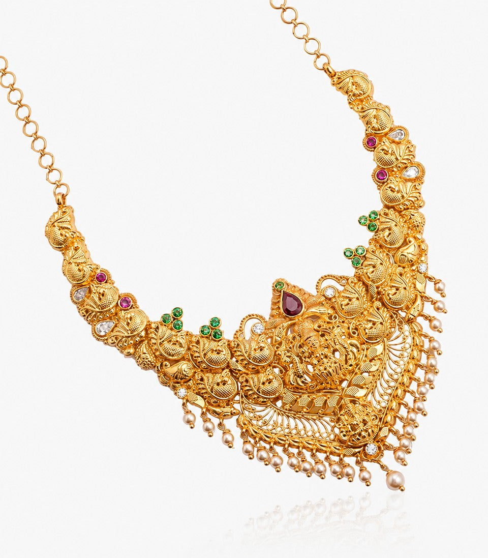 An Antique-Finish Gold Temple Haram Featuring A Central Goddess Lakshmi Pendant