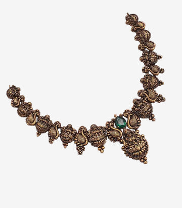 Decorative brass necklace with emerald stone on a white background