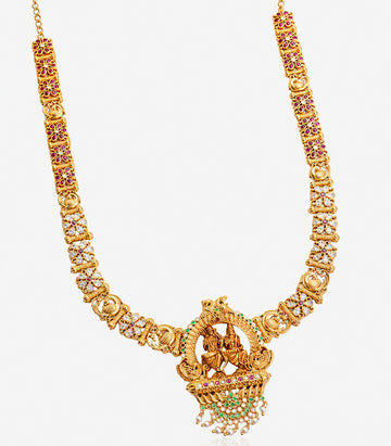 A Long Gold Temple Haram Featuring A Large Circular Pendant