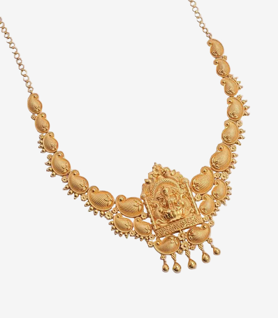 Gold necklace with intricate design and pendant on a light gray background
