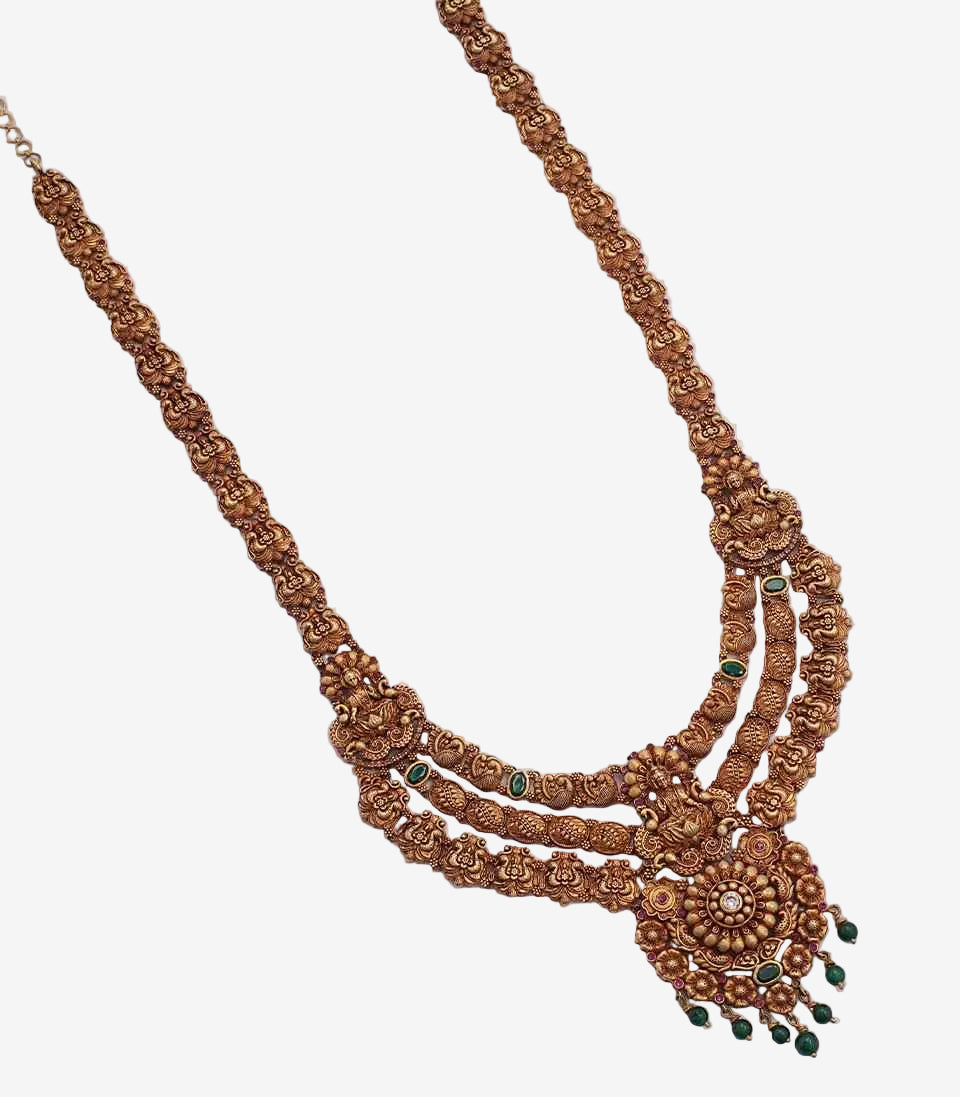 Decorative gold necklace with green stones on a white background