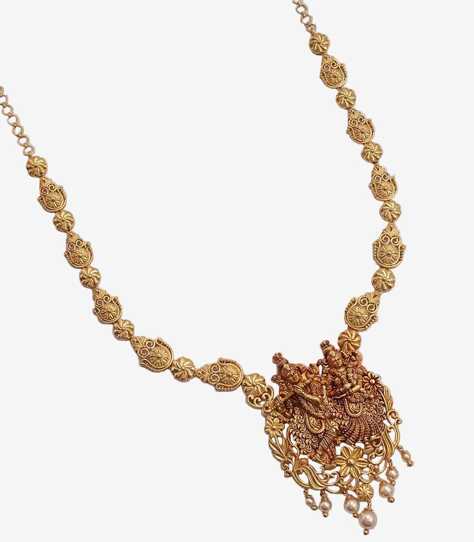 Gold necklace with intricate design on a light gray background
