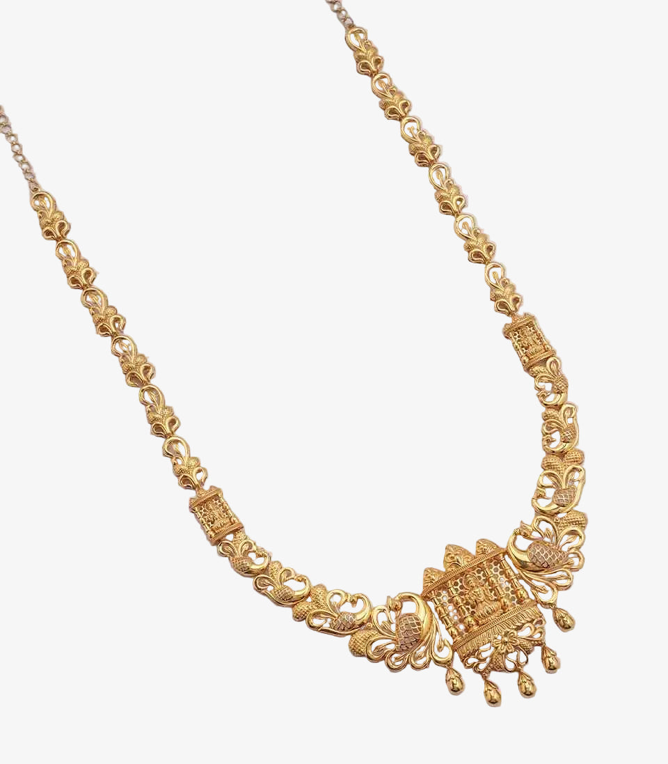 A long gold necklace featuring a chain of stylized floral and peacock links, with a rectangular temple-style pendant depicting a deity, flanked by peacock motifs and finished with small dangling gold droplets.