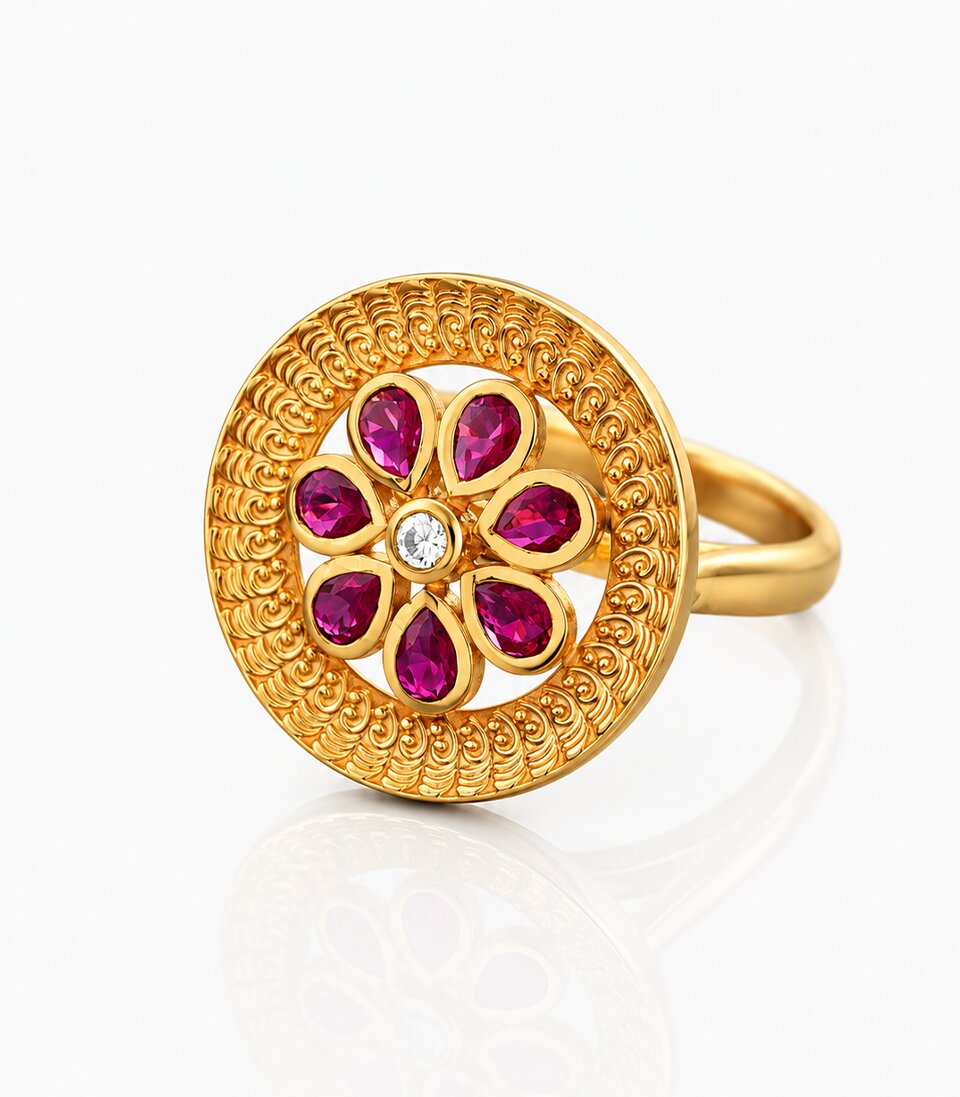Gold ring with red gemstones on a white background