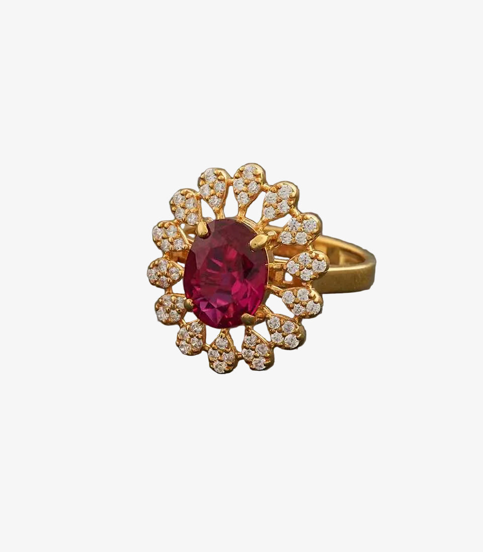 Gold ring with a red gemstone on a dark gray background