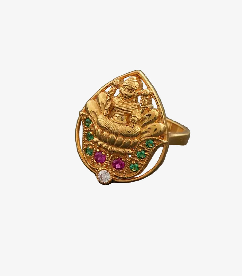 Gold ring with intricate Lakshmi design and Green and Pink gemstones on a dark gray background