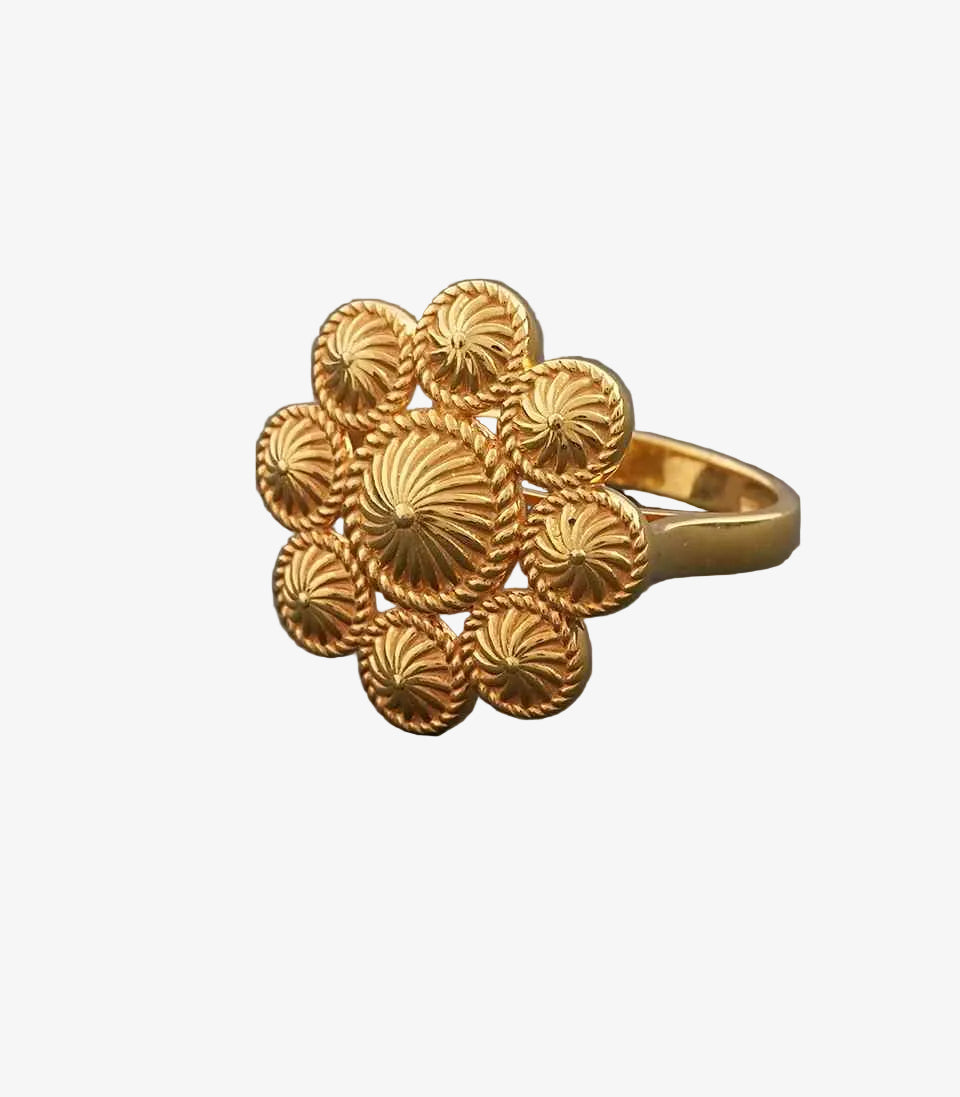 Gold ring with intricate design on a gray background