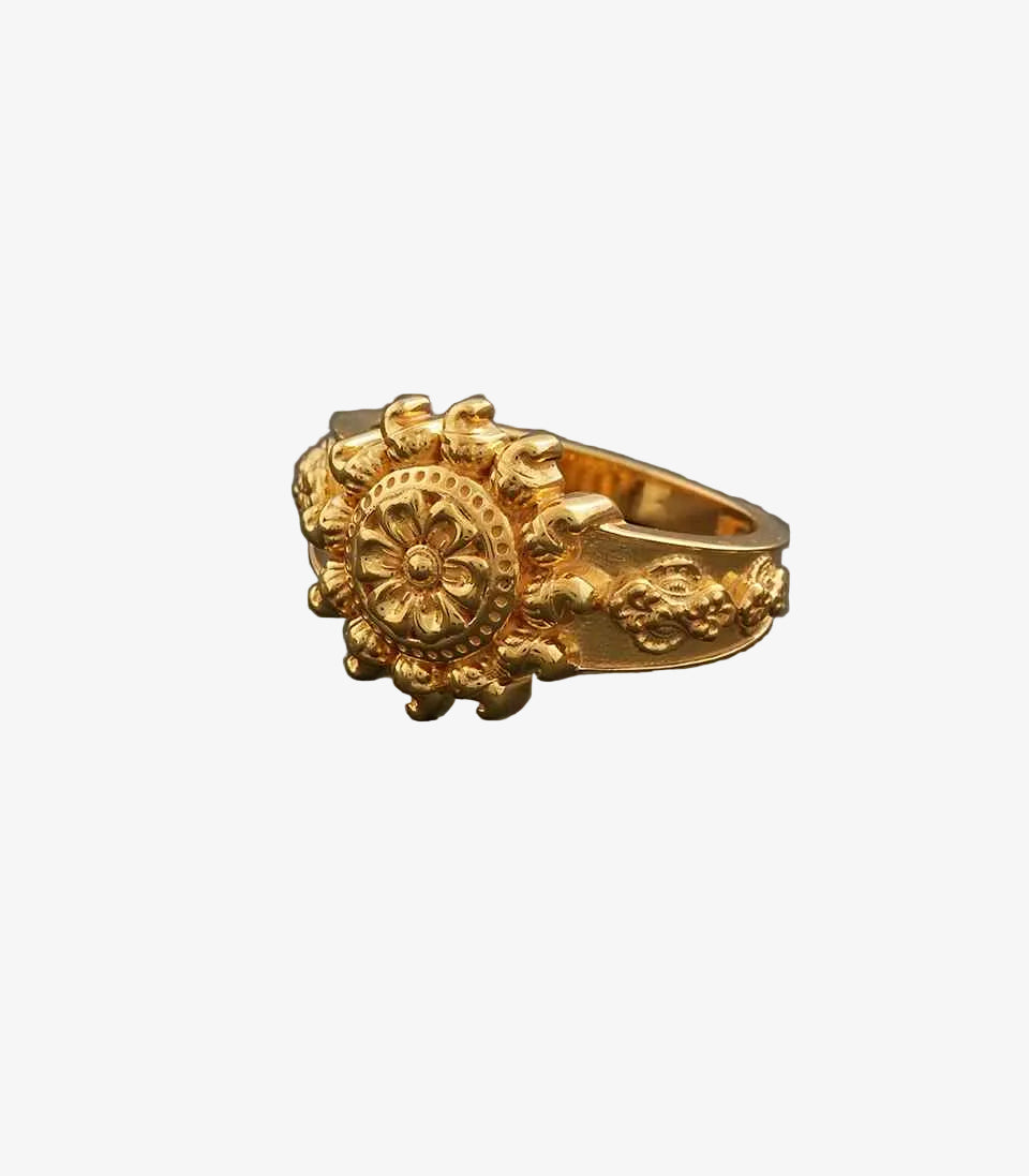 Gold ring with intricate design on a gray background