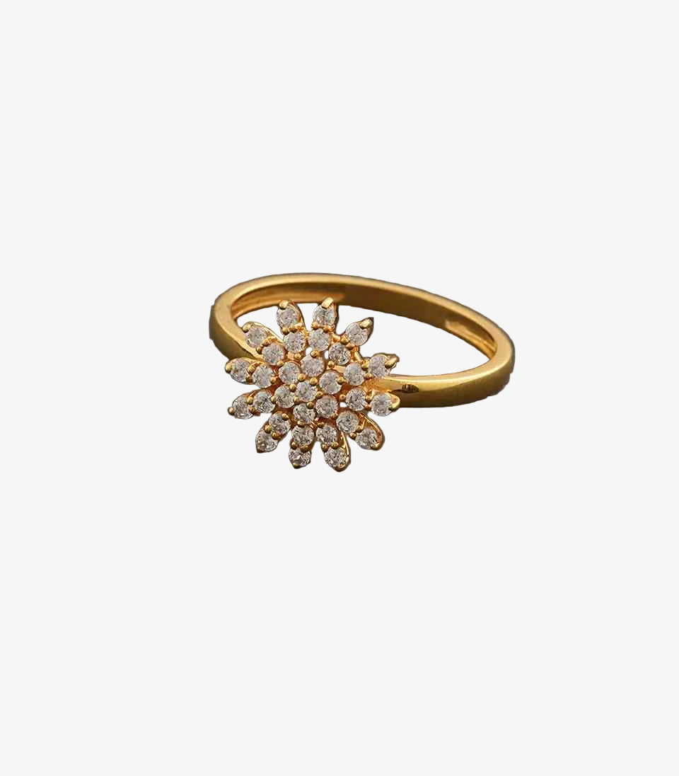 Gold ring with diamond flower design on a gray background