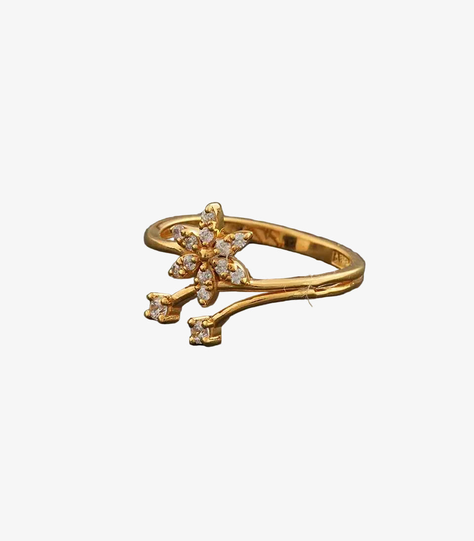 Gold ring with floral design on a gray background